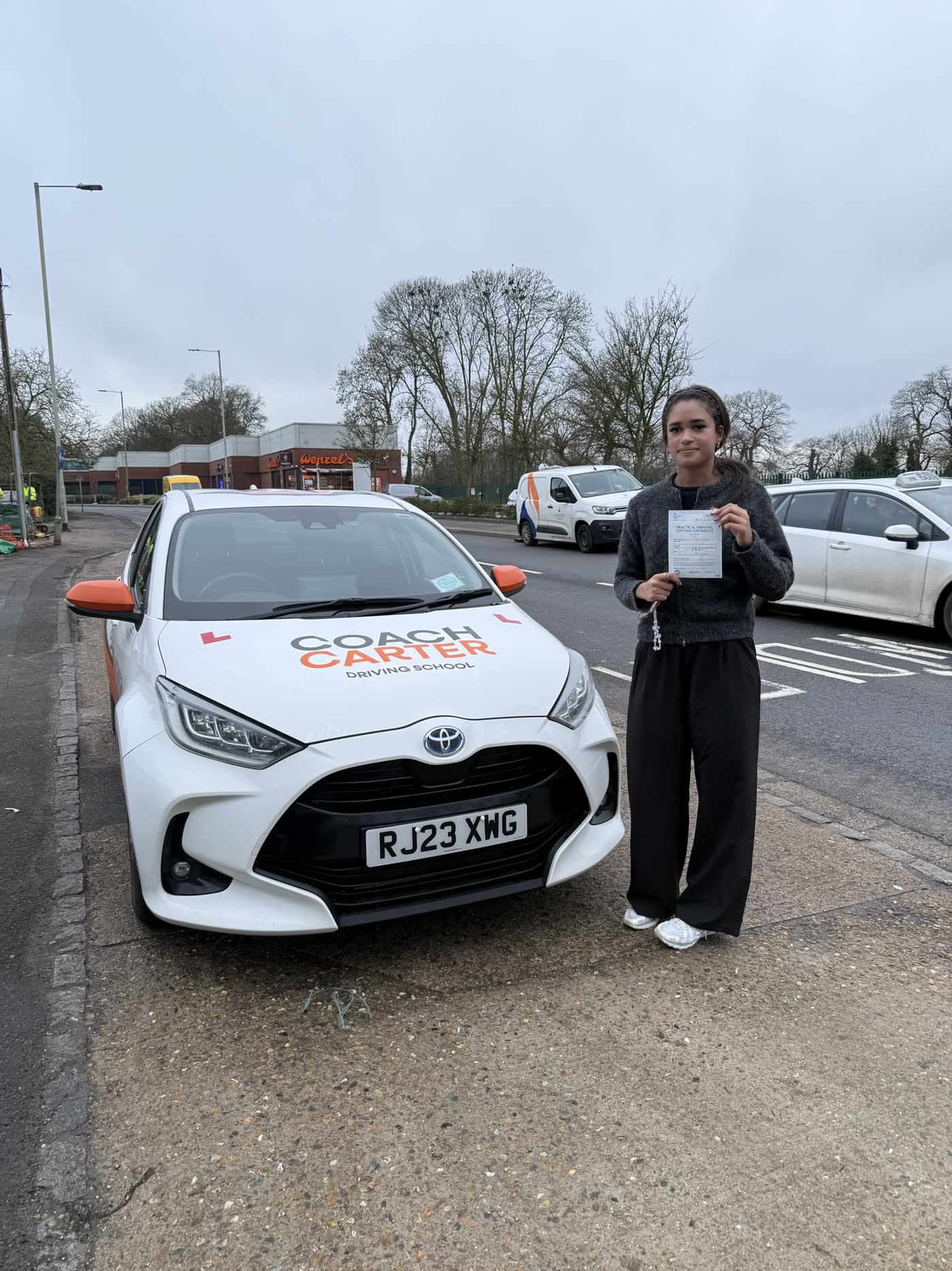 CoachCarter learner holding their driving test pass certificate